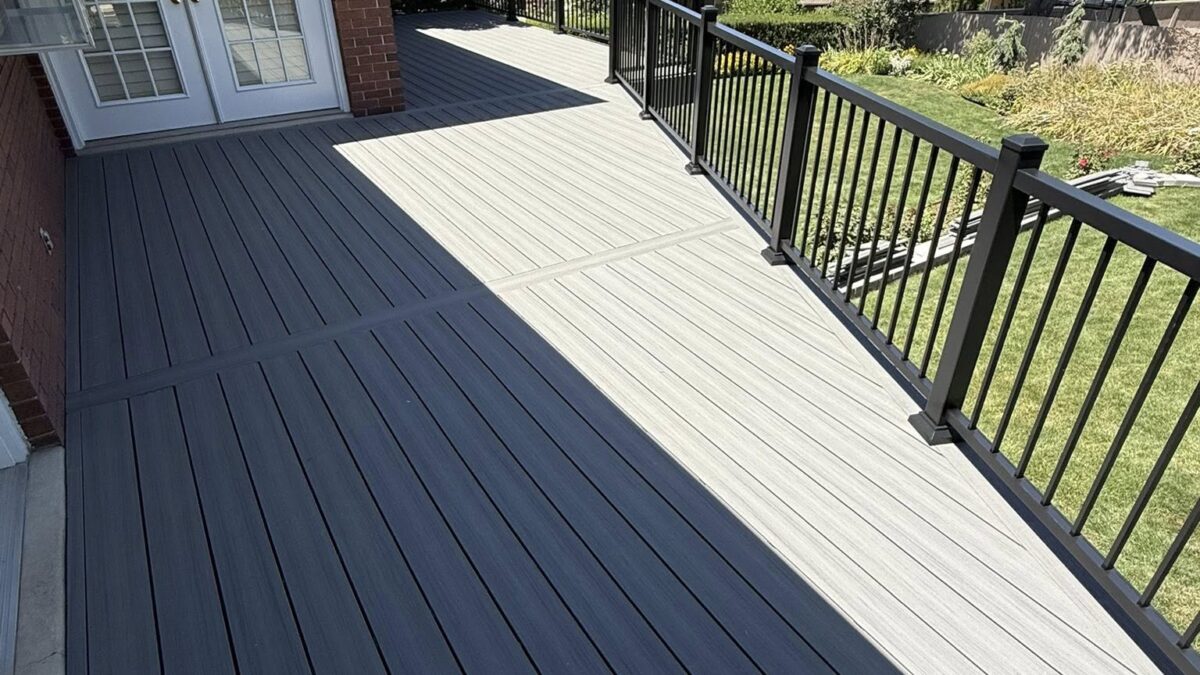 A beautiful grey deck in a Utah back yard with black railing.