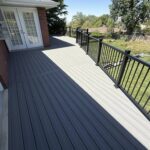 A beautiful grey deck in a Utah back yard with black railing.